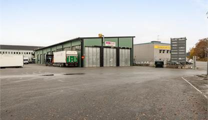Modern fasad med tydlig skyltning och hela åtta portar – perfekt för logistik och inlastning. Kumla Gårdsväg 13